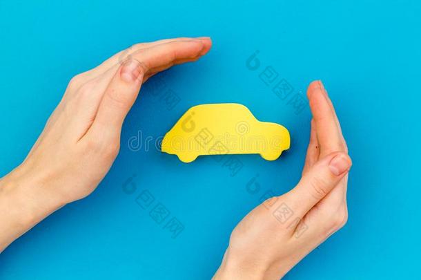 购买新的汽车观念和汽车玩具采用手向蓝色背景
