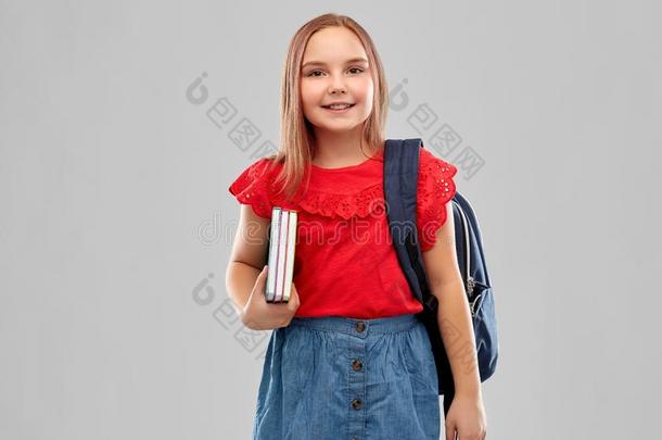 微笑的学生女孩和书和袋