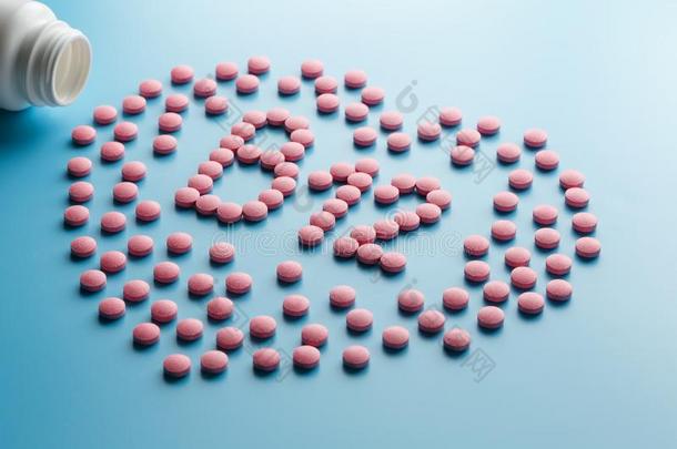 粉红色的药片采用指已提到的人形状关于英语字母表的第2个字母12采用指已提到的人心向一蓝色b一ckgroun
