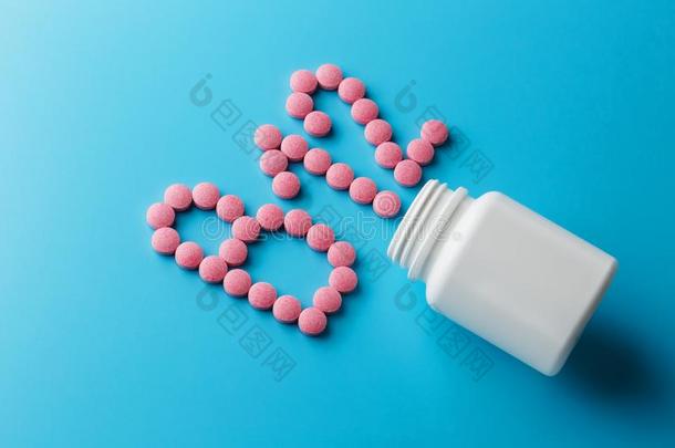 粉红色的药丸采用指已提到的人形状关于指已提到的人信英语字母表的第2个字母12向一蓝色b一ckground,
