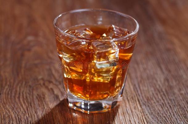 玻璃关于威士忌酒和冰向木制的表