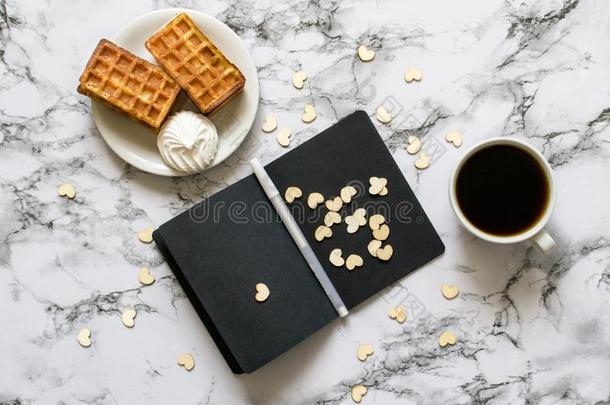 笔记簿和黑的纸向大理石背景和咖啡豆