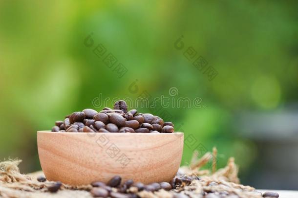 烤咖啡豆豆向木制的碗和麻袋/特写镜头咖啡豆是