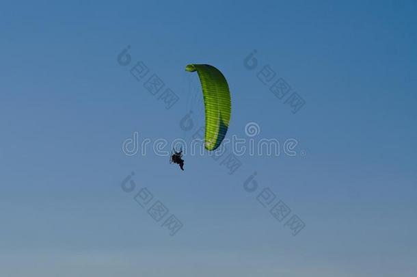 绿色的滑翔伞运动和蓝色天采用背景