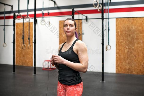 适合肌肉的年幼的女人运动员采用一健身房