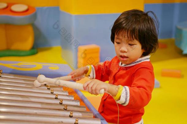 小的亚洲人婴儿女孩享有演奏一钟琴<strong>木琴</strong>
