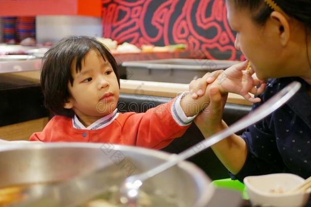 小的亚洲人婴儿女孩分配食物,焖罐<strong>菜肴</strong>,和她mot她