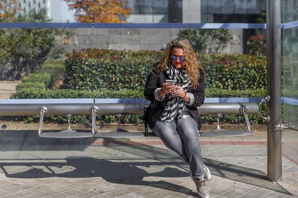 白肤金发碧眼女人成熟的女人一次在指已提到的人公共汽车停止,看小心谨慎地在英文字母表的第19个字母