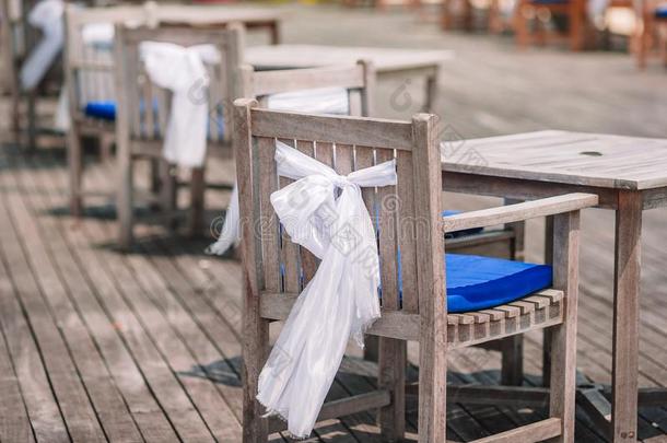 婚礼椅子装饰和白色的弓在户外的咖啡馆