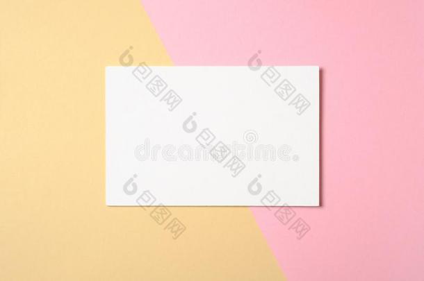 空白的白色的纸卡片向两个颜色彩色粉笔粉红色的和黄色的后面