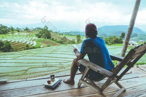 亚洲人男人<strong>旅行</strong>自然.<strong>旅行</strong>轻松.<strong>坐</strong>阅读书指已提到的人巴尔克