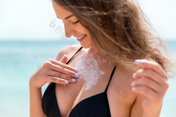 有魅力的女人是（be的三单形式应用防晒霜向她乳房和指已提到的人鱼鳍