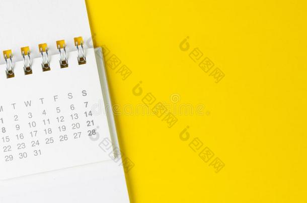 白色的干净的日历向固体的黄色的背景和复制品空间,