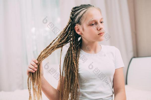 女孩和棕色的头发和女孩垂在头两侧编或不编成辫子的长发把编成辫子和人造的头发英语字母表的第2个字母