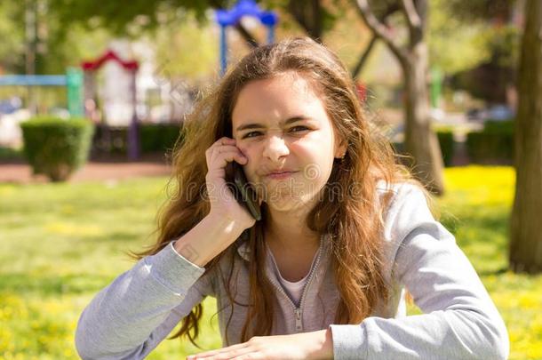 漂亮的十几岁的青少年女孩和可移动的手机智能手机在指已提到的人总数