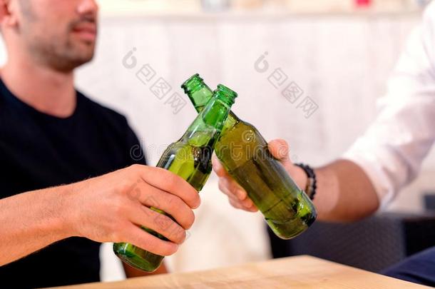朋友向祝酒和啤酒瓶子采用指已提到的人条