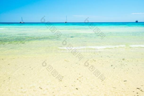 白色的沙海滩和清楚的海水在下面蓝色天