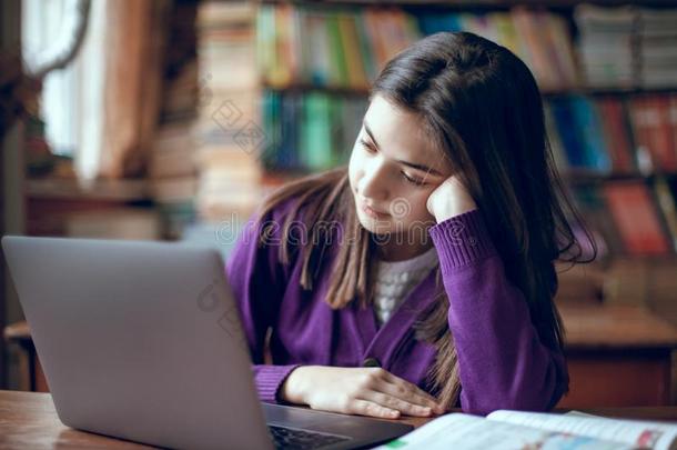 漂亮的学校女孩学习采用指已提到的人学校图书馆us采用g便携式电脑