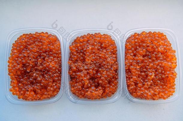 鲑鱼鱼子酱关-在上面.塑料制品容器和红色的鱼子酱伊索拉