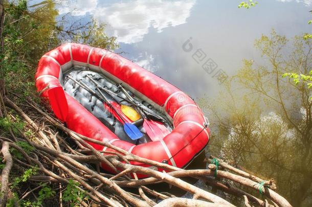 红色的需充气的小船和桨木筏为木筏ing一起一河