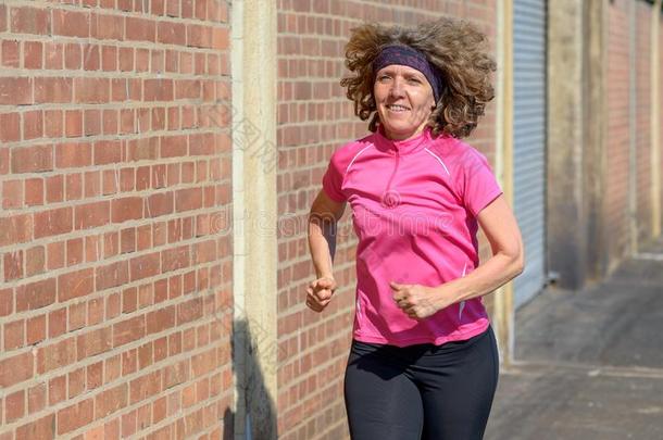 健康的女人慢跑采用城镇向指已提到的人人行道