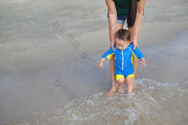 母亲和她婴儿步行第<strong>一级</strong>别向指已提到的人海滩