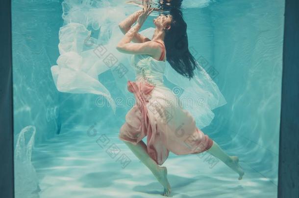 热的苗条的黑头发的妇女女人使摆姿势游泳在下面水采用美丽的