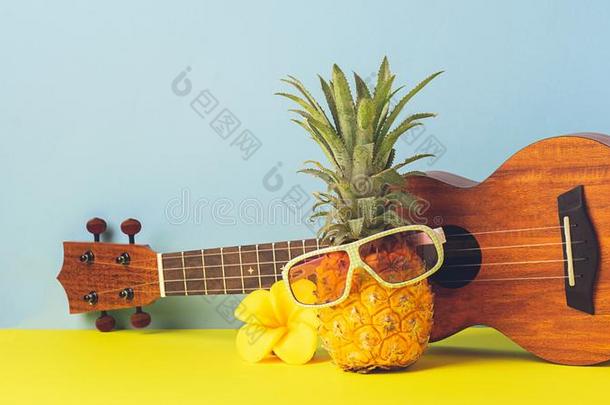 黄色的成熟的菠萝采用太阳镜.<strong>吉他</strong>向黄色的蓝色后面
