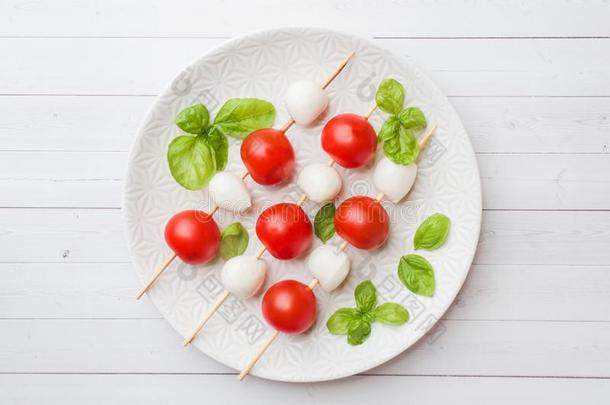 红白小碟沙拉关于番茄,意大利干酪奶酪和罗勒属植物向一极少的量