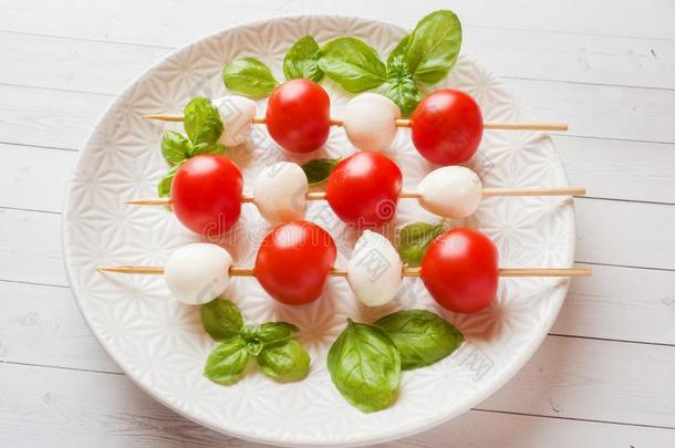 红白小碟沙拉关于番茄,意大利干酪奶酪和罗勒属植物向一极少的量