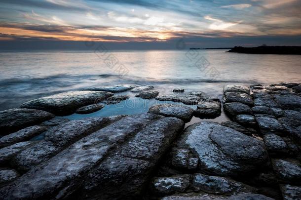 多岩石的湖安大略湖海岸线在日落