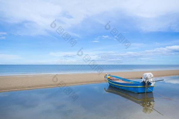 捕鱼小船在阳光向指已提到的人海滩和天背景