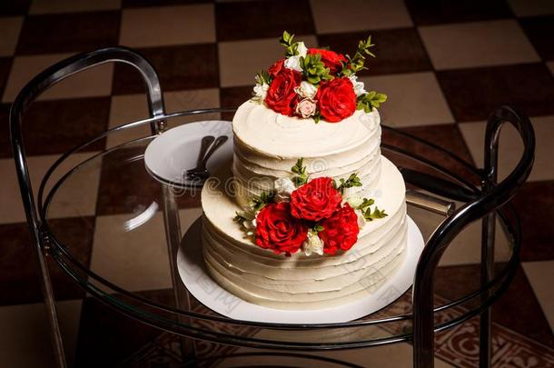 美味的两个-层层排列婚礼蛋糕向玻璃盘子和盘子和