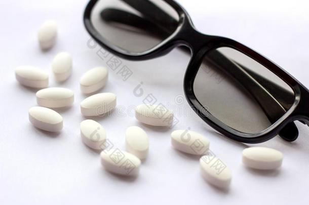 白色的药丸和药片和眼镜向光背景.制药公司