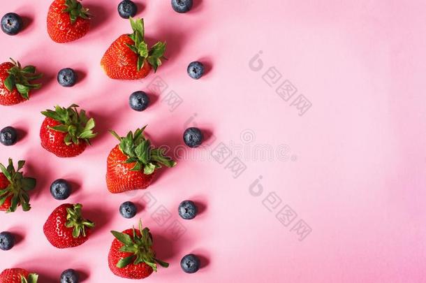 草莓和越橘的一种向粉红色的背景.草莓和
