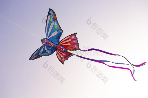 富有色彩的蝴蝶风筝和明亮的带是（be的三单形式飞行的采用指已提到的人天