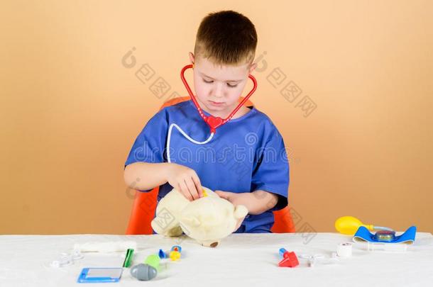 健康状况关心.小孩小的医生忙碌的坐表和医学的工具