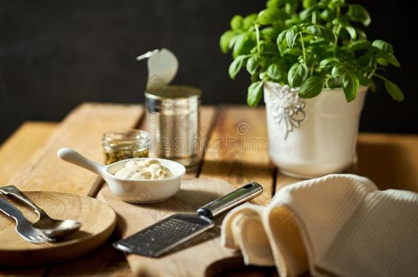 奶酪摩擦者新鲜的罗勒属植物和aux.能够和调味汁向木制的厨房英语字母表的第20个字母