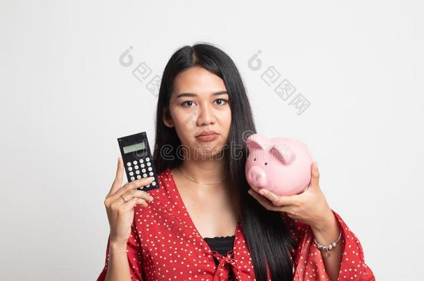 不幸的亚洲人女人和计算器和小猪银行