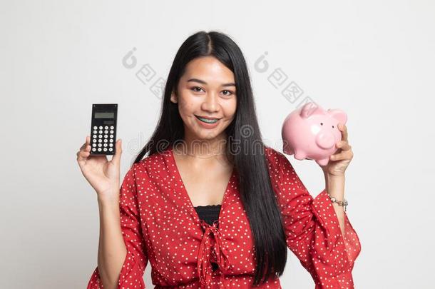 亚洲人女人和计算器和小猪银行