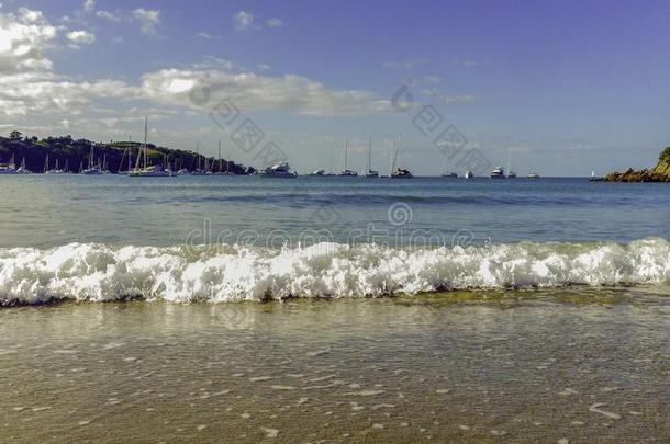全是泡沫的波浪向海滩和小船采用指已提到的人背景