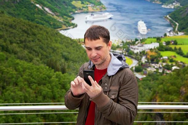 旅行者拿自拍照在近处盖朗厄尔海港挪威