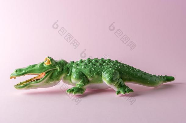 绿色的<strong>鳄鱼玩具</strong>向彩色粉笔粉红色的背景.最小的艺术c向ce
