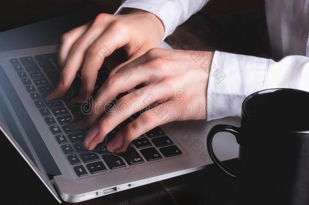 商业男人打字向便携式电脑键盘在期间手指和调趺