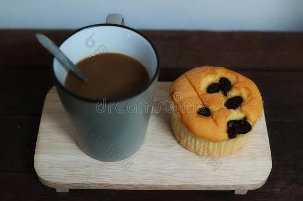 咖啡豆杯子和葡萄干纸杯蛋糕粘贴向木制的盘子,指已提到的人全音阶的第7音