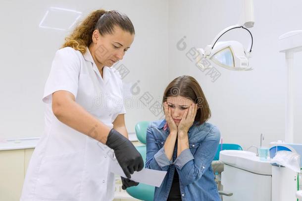 成熟的女人和牙痛讲话向专业的牙科医生,女子