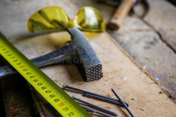 黄色的测量值带子,铁锤,钉子,保护镜片