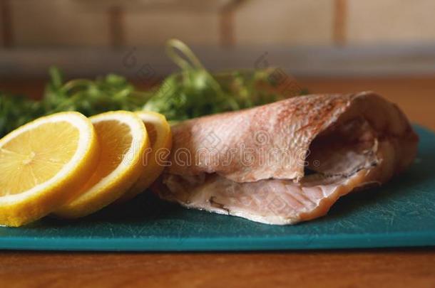 新鲜的鱼,生的鳕鱼用带缚或装饰和加关于草本植物和柠檬