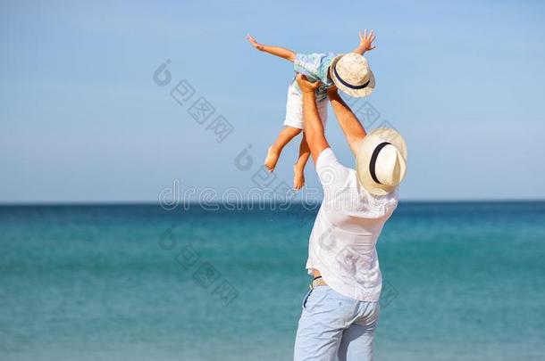 幸福的家庭父亲和小孩儿子在海滩