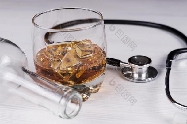 <strong>酒精中毒</strong>.听诊器,玻璃和白兰地酒的一种一空的瓶子